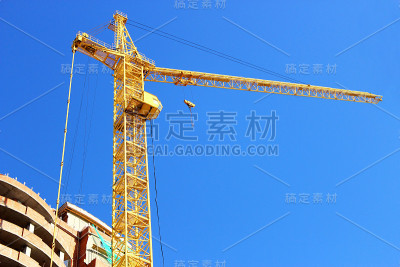 高层建筑起重机靠近正在施工的房屋。