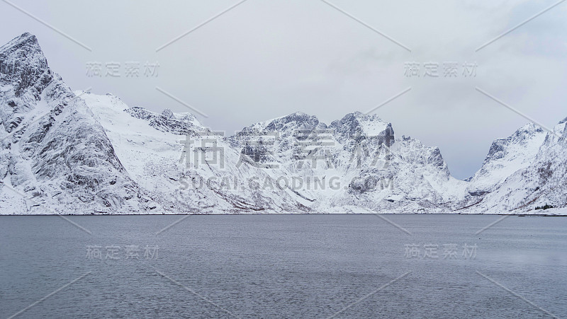 罗浮敦群岛，北欧郡，挪威，欧洲。白雪皑皑的山峦和树木，是冬季自然景观的背景。著名的旅游景点