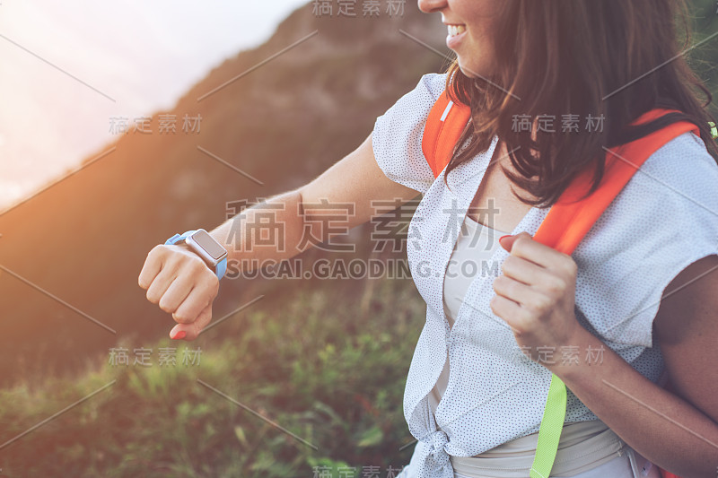 在山里旅行的女人在看智能手表