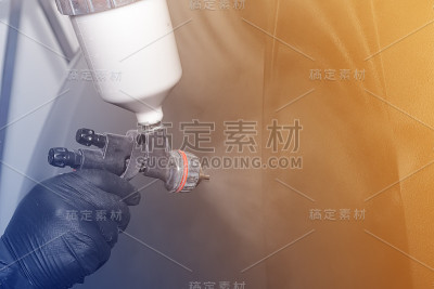 油漆汽车零件，一个男人用喷枪，修理汽车车身