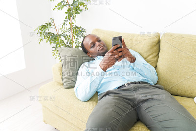 一个在家里用智能手机的黑人