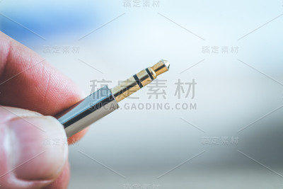 音频插孔概念:靠近男性手指持有3.5毫米音频插孔
