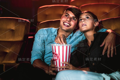 男人和女人在电影院看电影。
