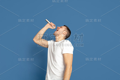 蓝色画室背景上的白人青年肖像