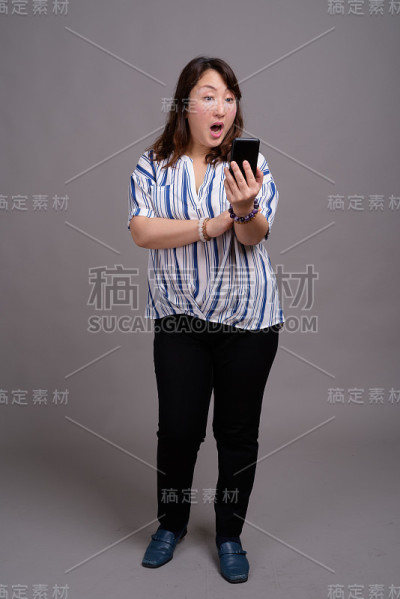 工作室拍摄的成熟美丽的亚洲女商人在灰色的背景
