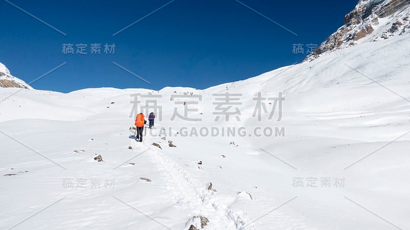 人们在新雪中攀登安纳布尔纳峰