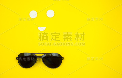 黑色手机，黄色背景的太阳镜。前视图。本空间
