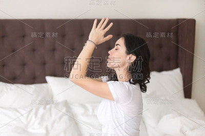 年轻迷人的女人在床上沉思，侧影