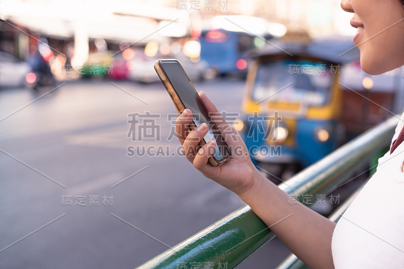 不同的千禧女孩使用电子移动设备应用程序在市中心的城市街道等出租车