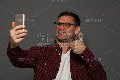 帅哥在智能手机上自拍