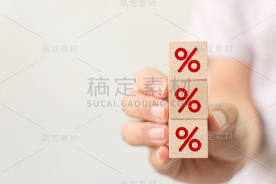 利率金融和抵押贷款利率概念。手握木方块增加与图标百分比符号向上的方向