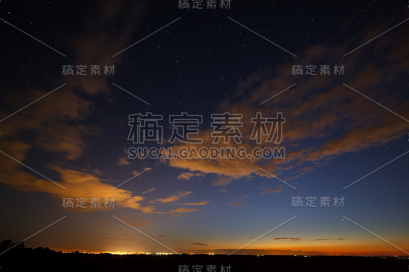 晚霞过后，夜空中以明亮的星星为背景的云。