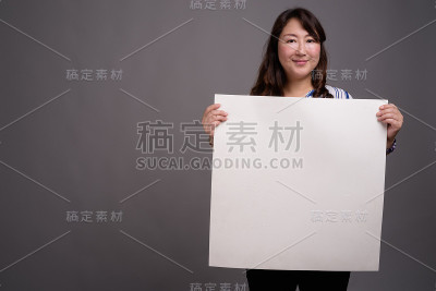 工作室拍摄的成熟美丽的亚洲女商人在灰色的背景
