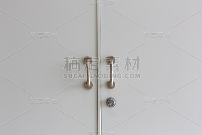 灰色门关闭。带有金属和铝把手的木门关闭
