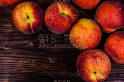新鲜成熟的桃子放在木桌上。俯视图