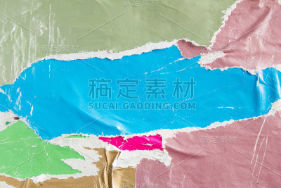 彩色的撕破破旧和皱巴巴的纸海报在城市墙体广告牌与旧撕破剥落海报纹理背景。文本信息的空间。