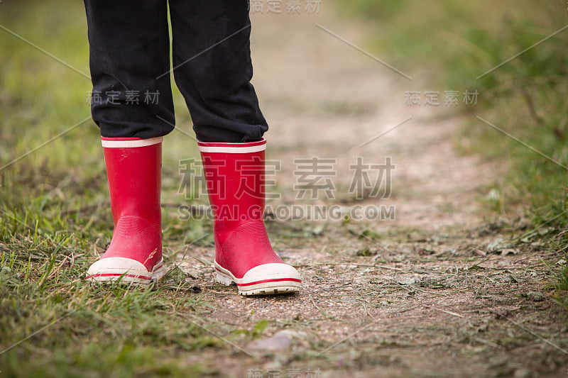 穿着雨靴的小男孩。腿的射门