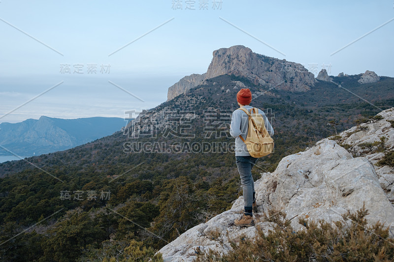 男人背包徒步旅行和红帽子在山区