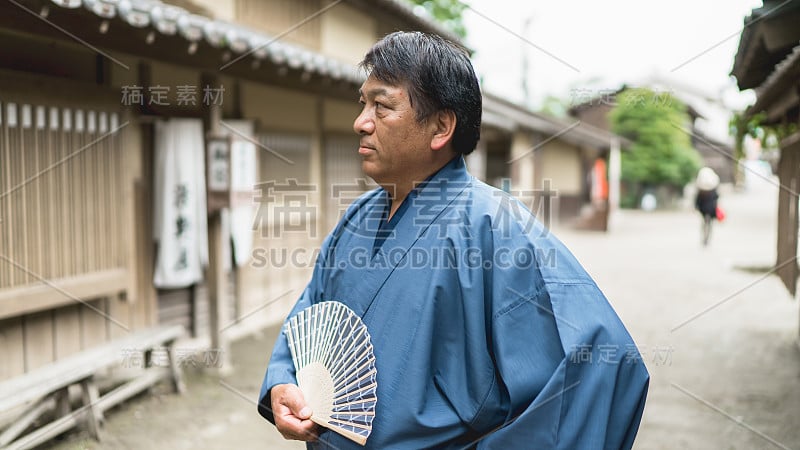 一个日本成年男子站在老城区的侧面