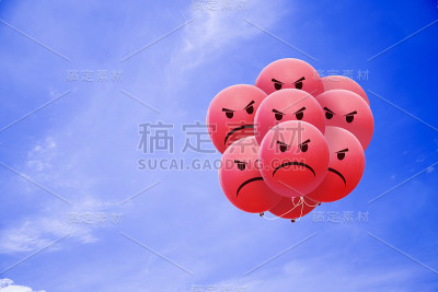 明亮愤怒的气球在蓝色的天空中飞翔