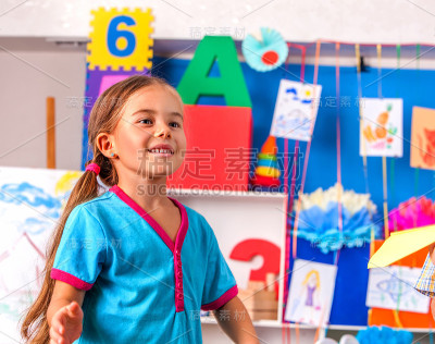 幼儿园里拿着毛笔画画的女孩。