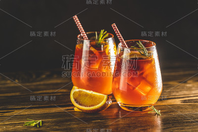 两杯意大利雪碧鸡尾酒和橙片水滴。米兰烈酒鸡尾酒，配红酒、干白葡萄酒、苏打水、红橙和冰。黑暗的背景，惊