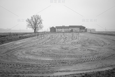 有未耕种田地的旧农场。黑白照片