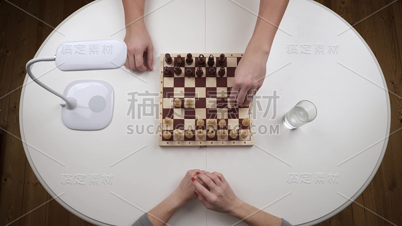 这对夫妇下棋。女人输掉了比赛，扔出了数字。前视图。手近视图