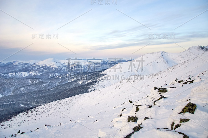 白雪皑皑的山峰映衬着连绵的山脉。徒步登山。