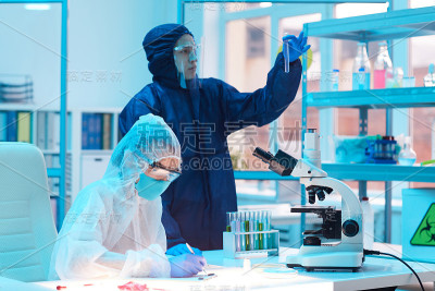 两个穿着防护服的工作人员在实验室