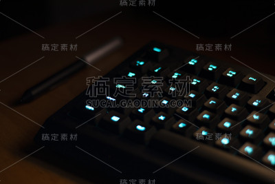 键盘与蓝色背光在工作台上，按钮灯