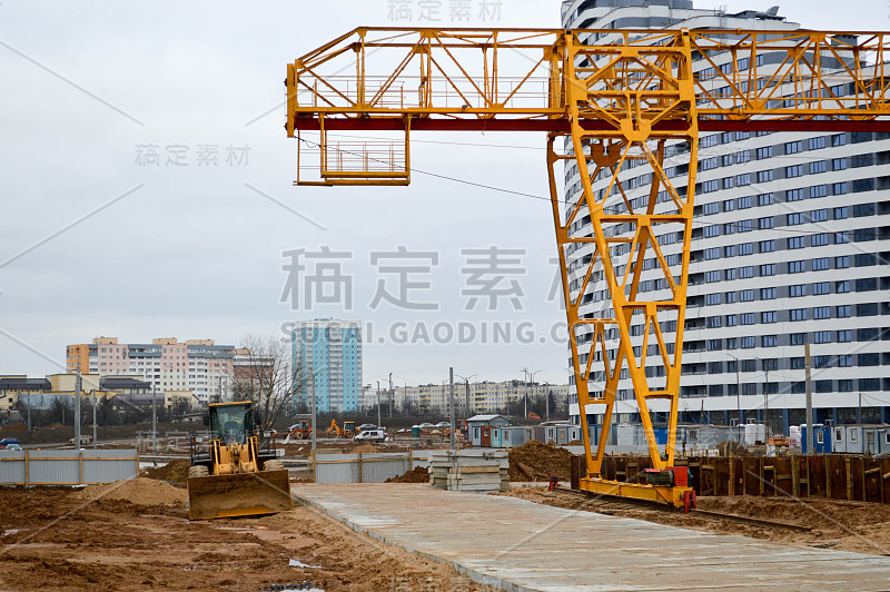 一个大型的现代化建筑工地，在建筑和房屋用电器和许多高大的塔和固定式工业强大的起重机和建筑材料