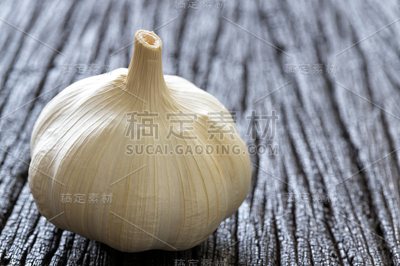 生大蒜在深色木质背景上。