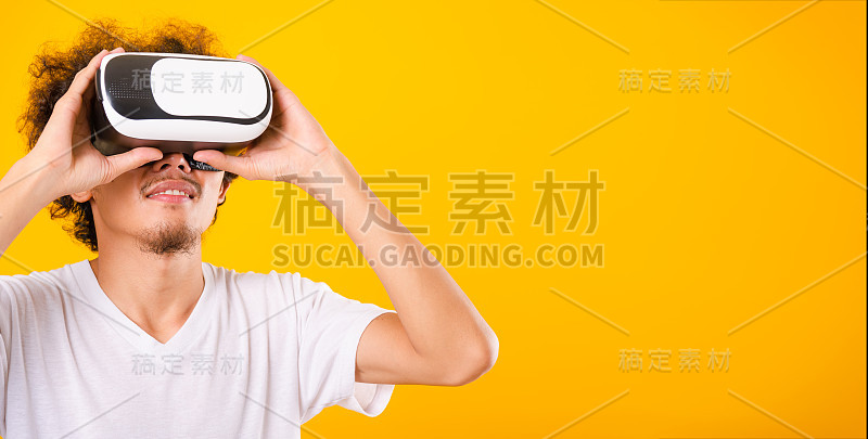 亚洲英俊的卷发男子他使用虚拟现实头盔或VR眼镜隔离