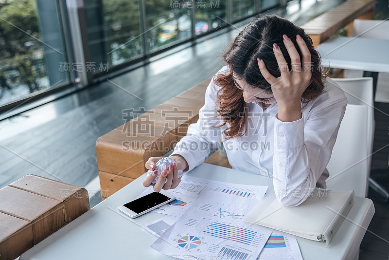 肖像美丽的亚洲女人是破坏财务图表文件和感觉'抱怨和愤怒。