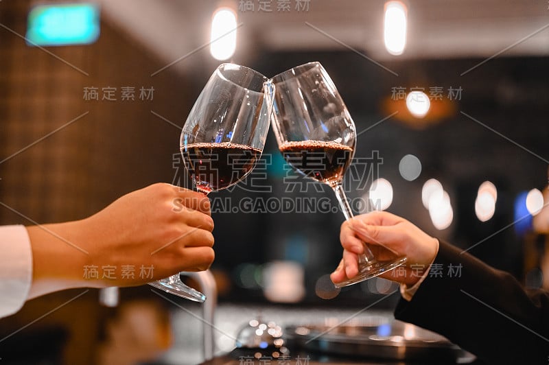 两位调酒师在日落时分的餐厅品酒活动中享用一杯酒。酒保，品酒，晚餐，葡萄酒，饮料，晚餐概念。