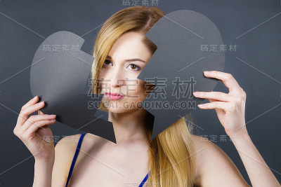 年轻悲伤的女人被破碎的心所覆盖。