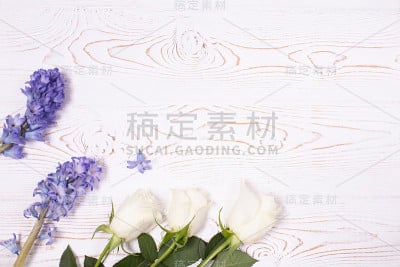 顶视图蓝色的花风信子和白色玫瑰在白色木制桌子与文字空间