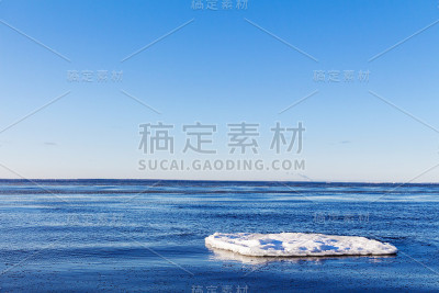 冰漂浮在冰冷的蓝色水中