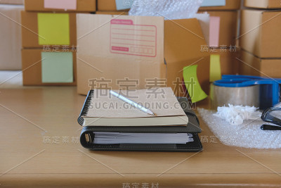 笔记本，小企业主工作场所的包装配件。用于网上销售的纸板箱。企业家卖方的书桌上。电子商务、运输概念