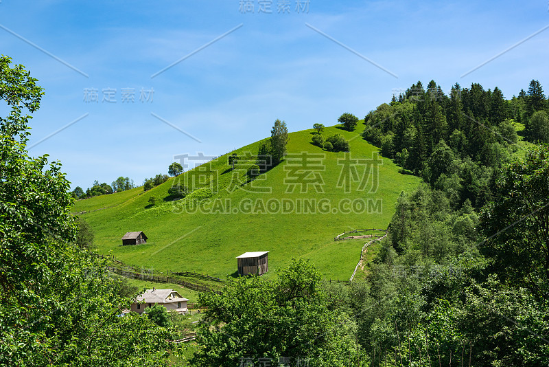 绿色的山和蓝色的天空。山区的乡村景观。待在村子里。