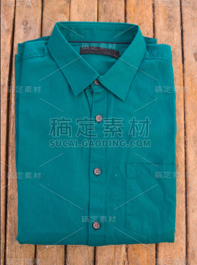 木制背景上的绿色衬衫