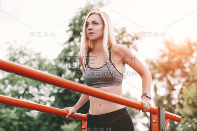 金发健身女孩在户外健身房做俯卧撑