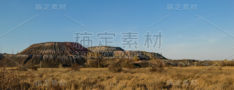 工业景观:煤矿开采后的废弃物。草原草和天空。