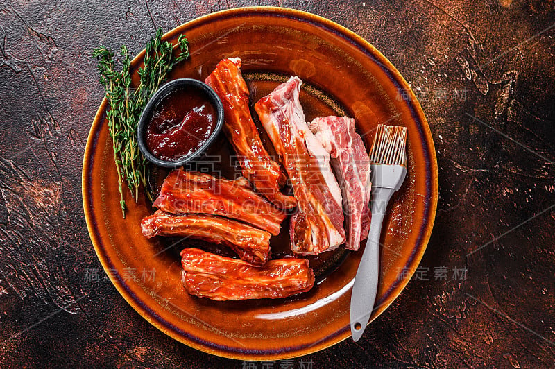 用烧烤酱腌过的小牛肉片，小排骨。黑暗的背景。俯视图