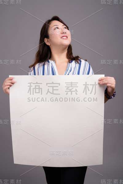 工作室拍摄的成熟美丽的亚洲女商人在灰色的背景