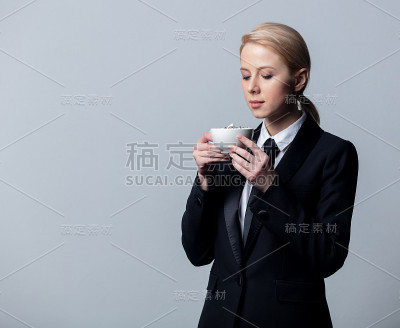 穿着经典黑色西装，喝着咖啡的女商人