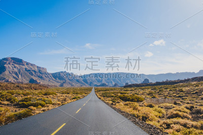 笔直空旷的公路在沙漠山谷景观和山脉背景下，