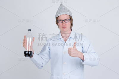 年轻的医生戴着锡纸帽，拿着一瓶苏打水，竖起大拇指