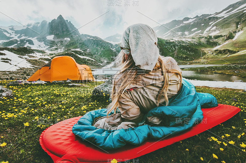 女人放松在红色垫子的睡袋露营旅行假期在山区生活方式概念冒险周末户外野生自然